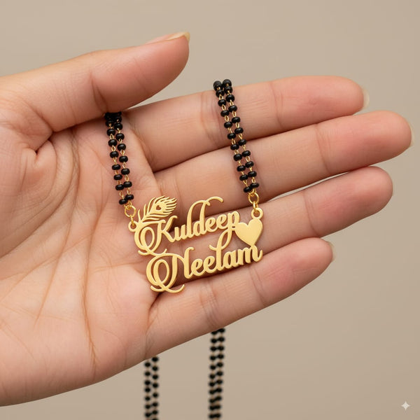 Gold name pendant on a black beaded chain held in a hand against a beige background