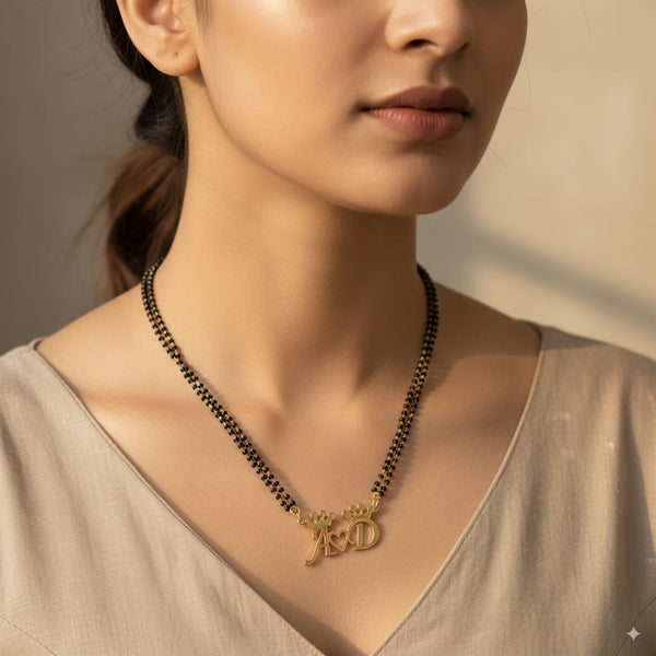 Woman wearing a gold necklace with a 'D' pendant on a neutral background